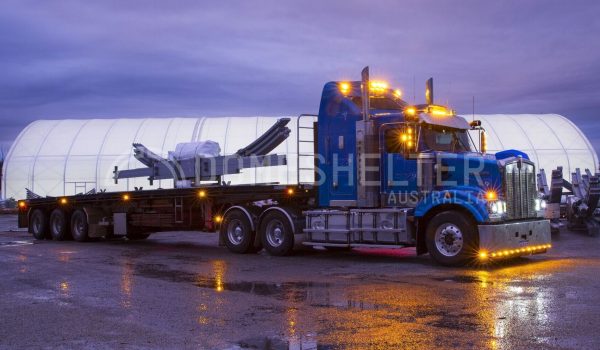 Truck parked in the rain in front of a Post Mounted Dome Fabric Structure